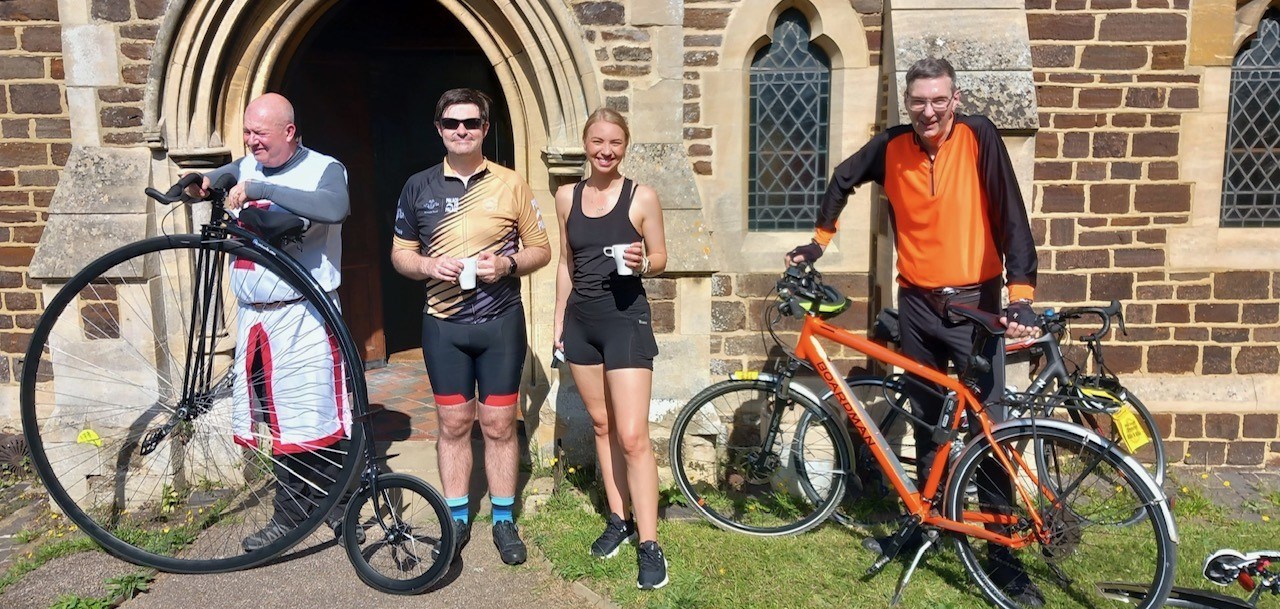 4 people standing with bikes