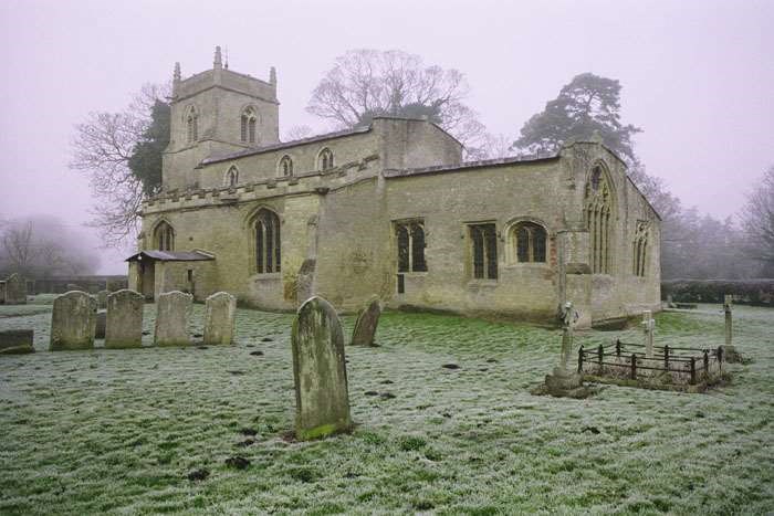 ancient church in churchyard on frosty day